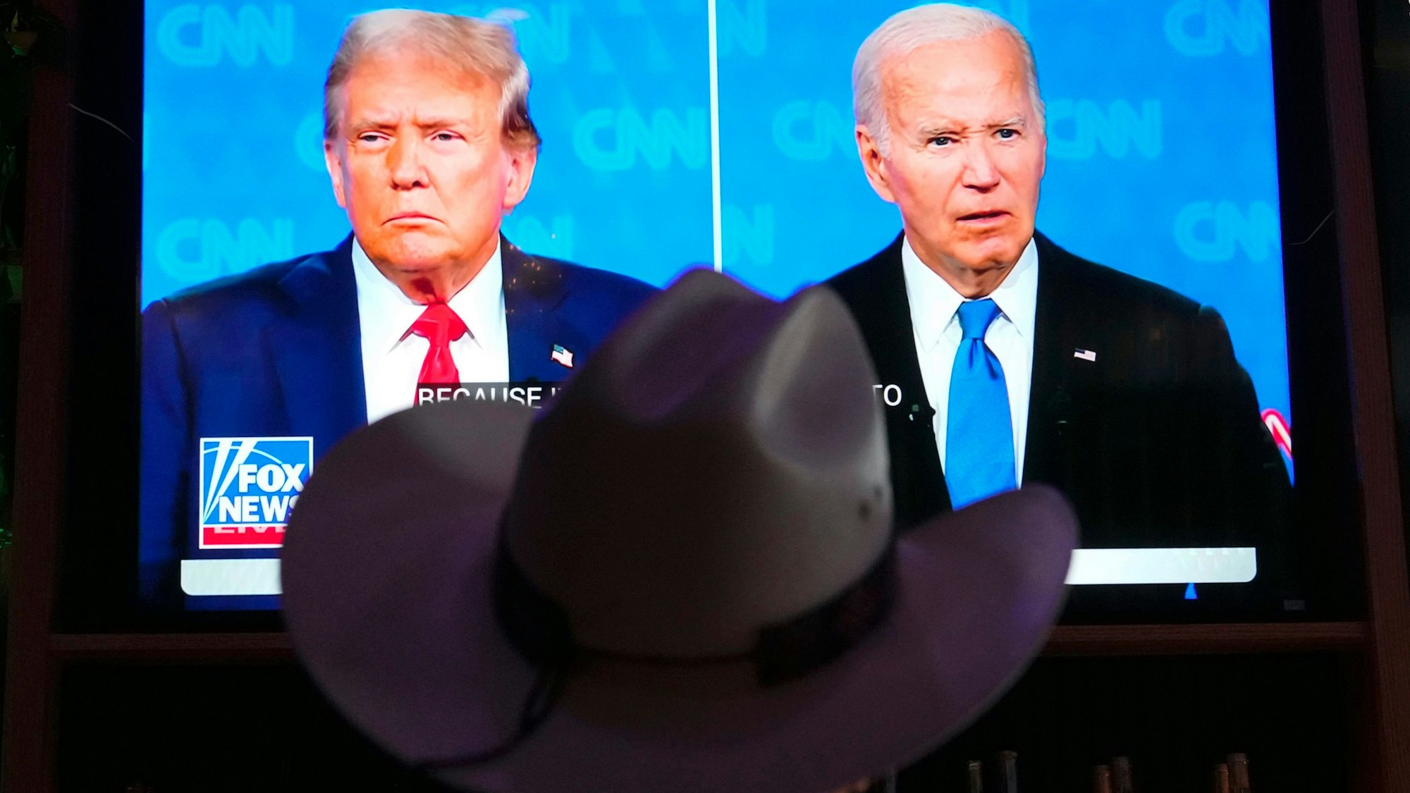 Ein Mann mit einem Cowboy-Hut schaut das TV-Duell zwischen Donald Trump und Joe Biden.