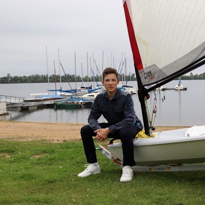 Florian Tempel sitzt am Zülpicher See auf seinem Segelboot.