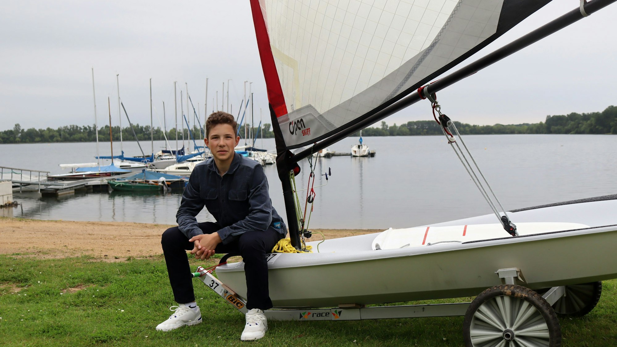 Florian Tempel sitzt auf seinem Segelboot am Zülpicher See.