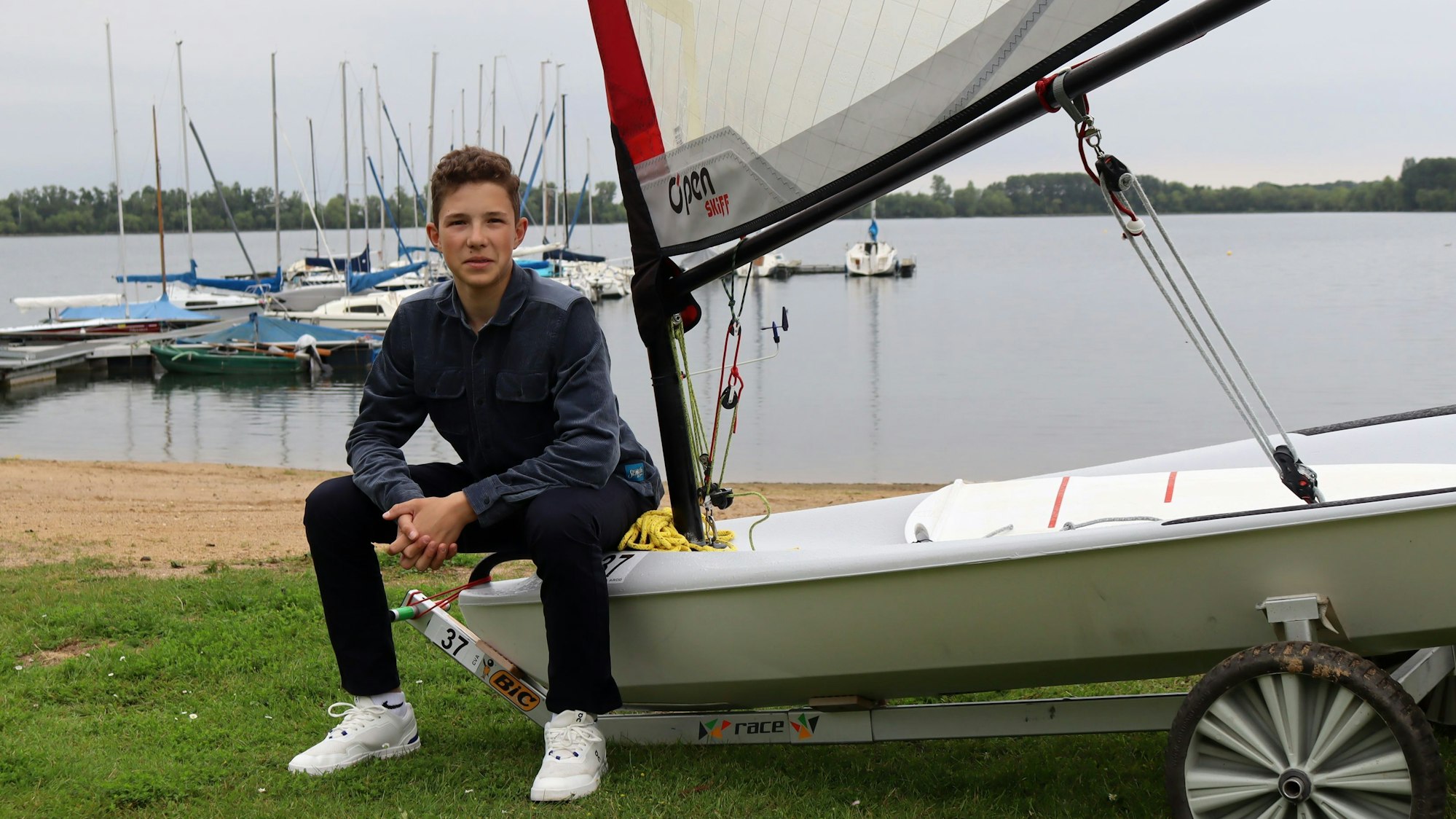 Florian Tempel sitzt am Zülpicher See auf seinem Segelboot.
