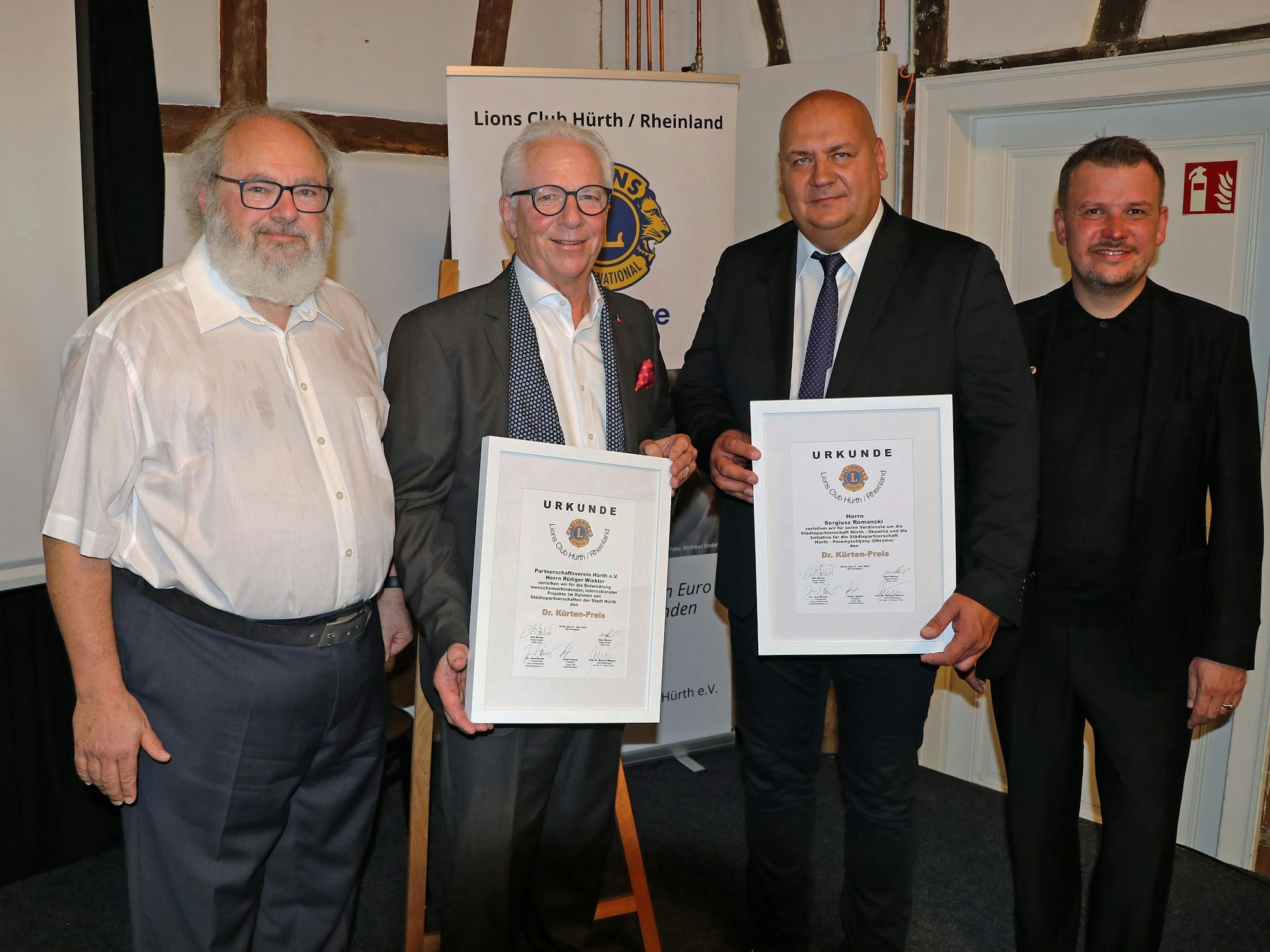 Die beiden ausgezeichneten Funktionäre mit Urkunden, daneben stehen Professor Dr. Michael Willems und Lions-Präsident André Jansen.