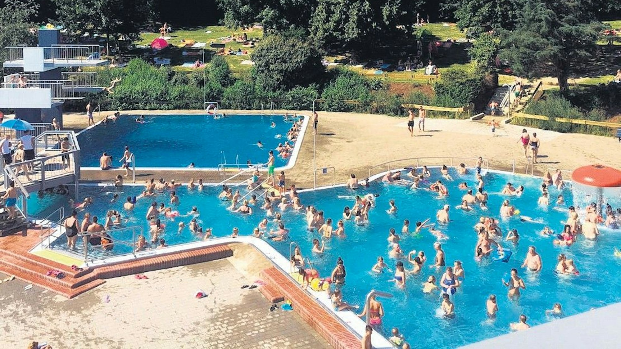Zu sehen sind zwei Schwimmbecken des Freibades mit Badegästen.