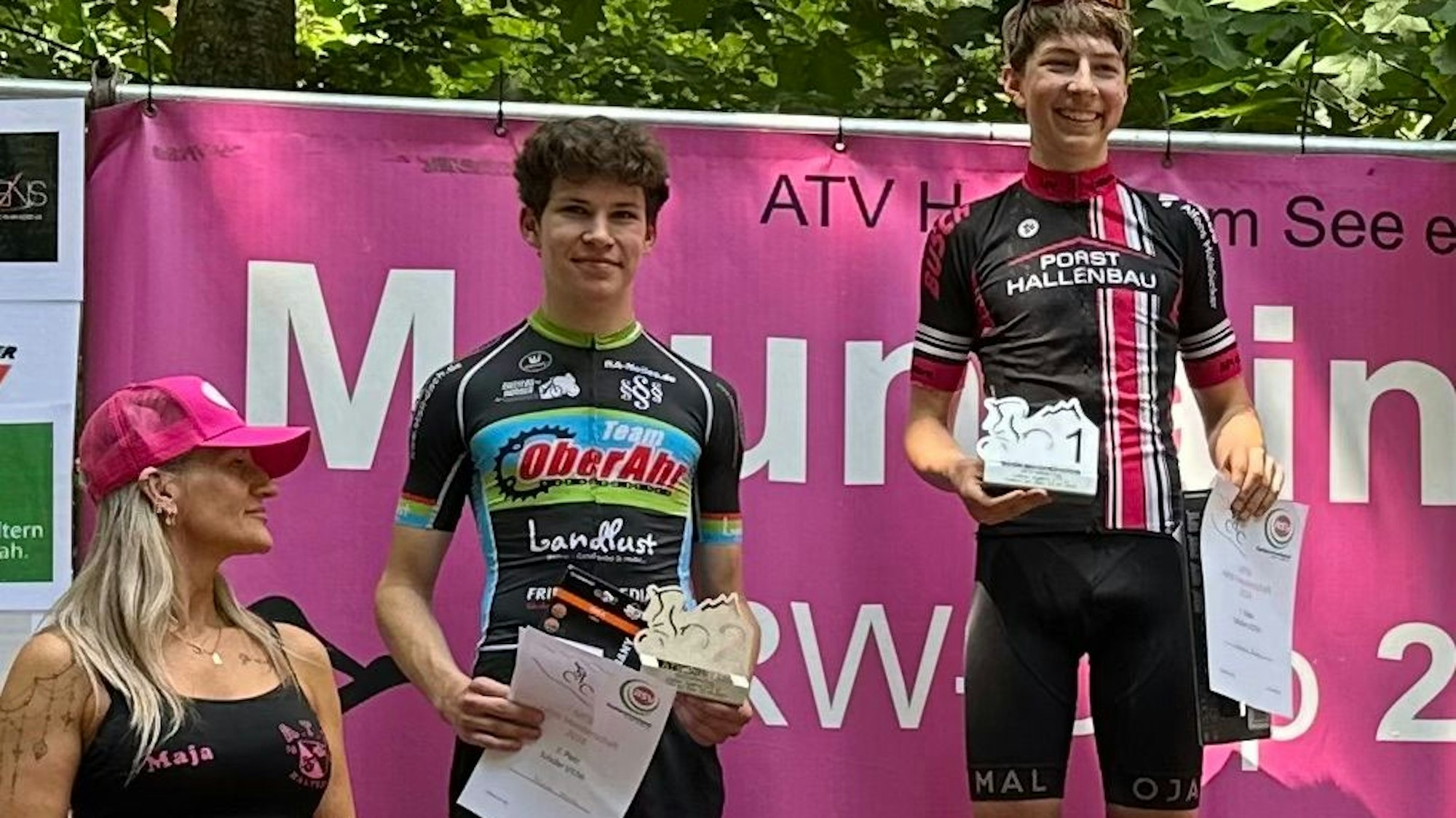 Siegerfoto in der U17-Altersklasse. Neben den beiden Erstplatzierten steht eine Frau mit rosa Kappe.