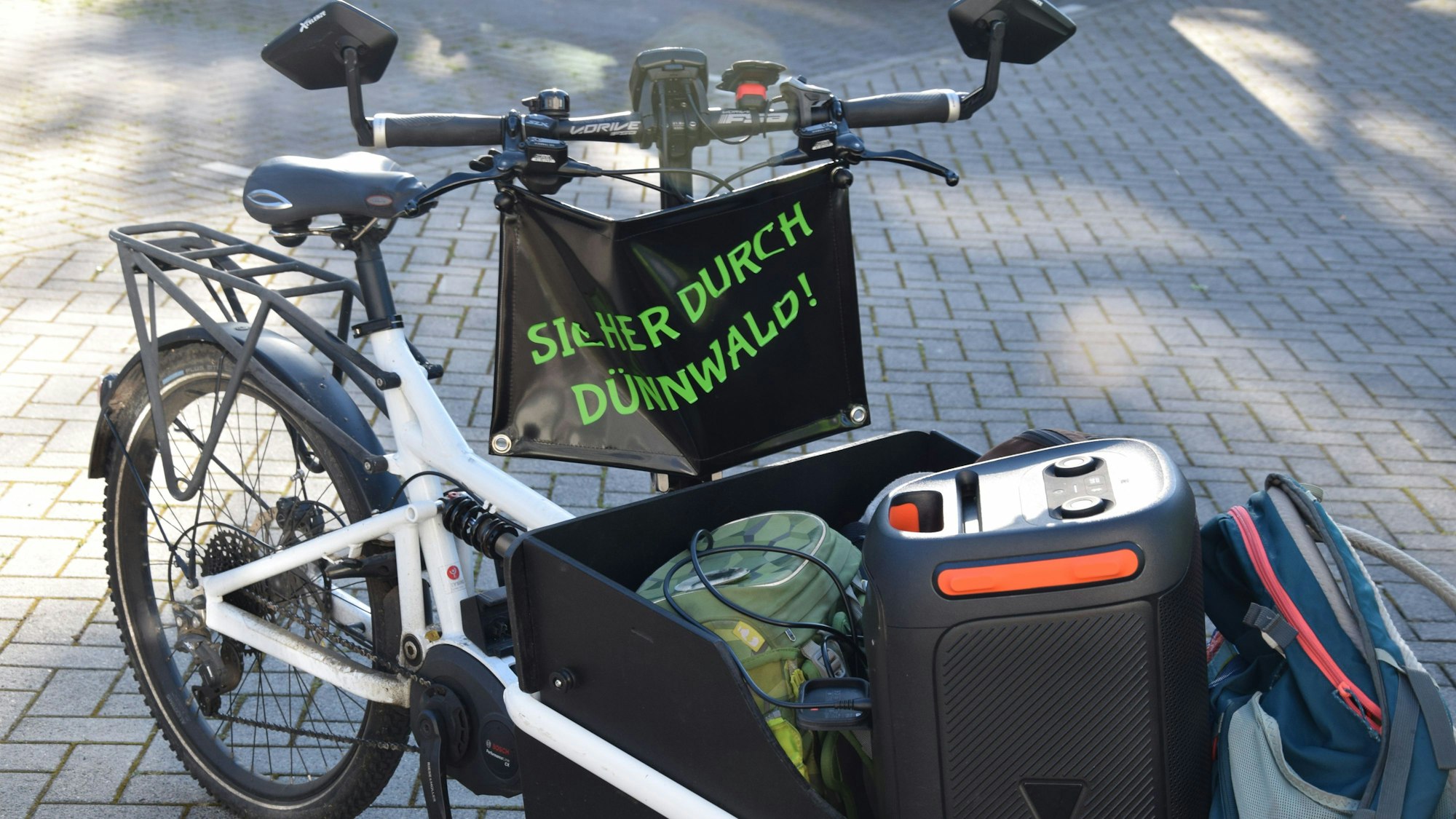 „Sicher durch Dünnwald“ steht am Lastenfahrrad von Stefan Kossmann, der den Fahrradbus anführt.