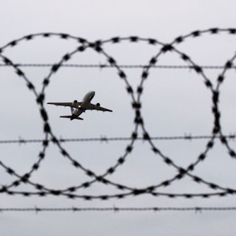 Ein Flugzeug startet am Flughafen Hannover, fotografiert durch Stacheldraht am Flughafenzaun. (Symbolbild)