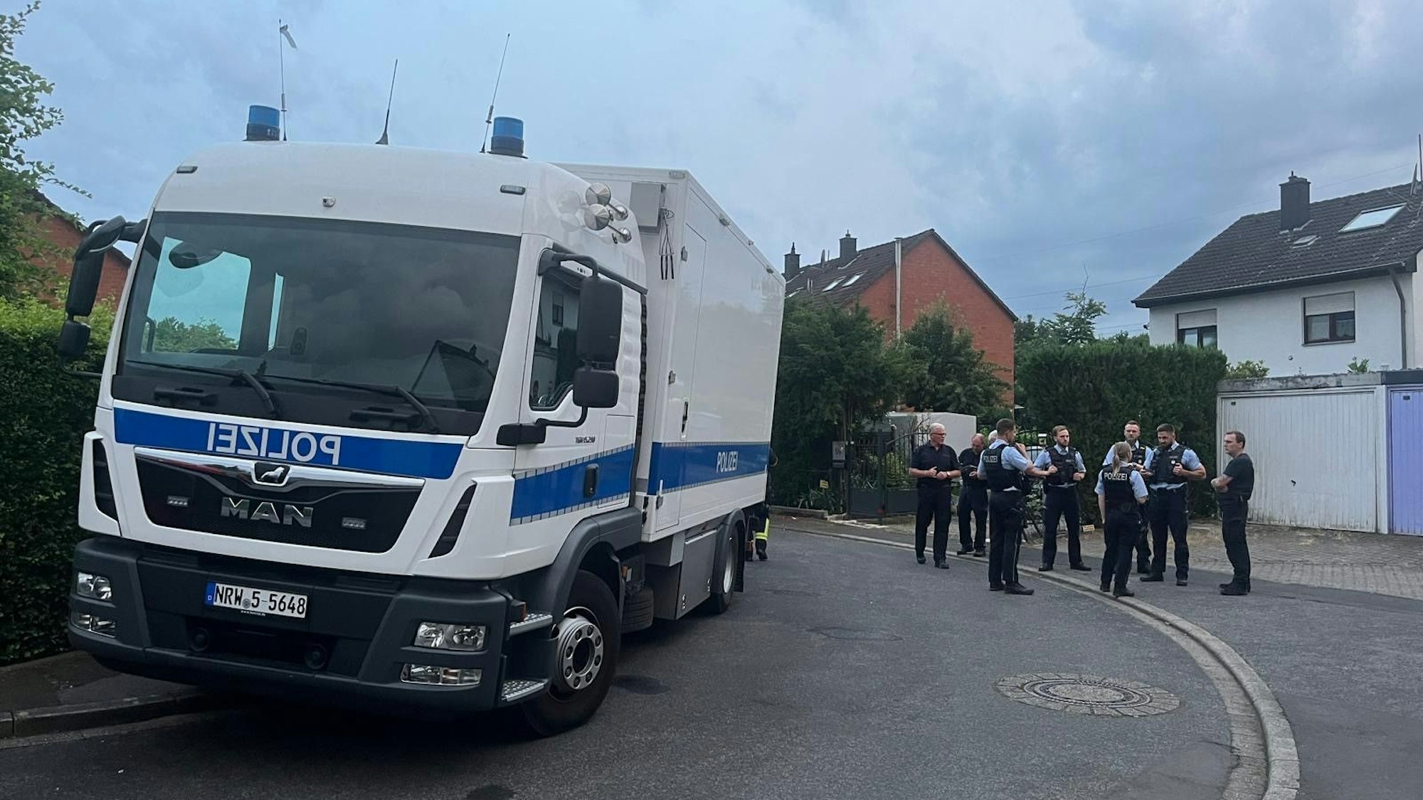 Ein Lkw der Polizei und mehrere Beamte stehen auf der Straße in Lohmar.