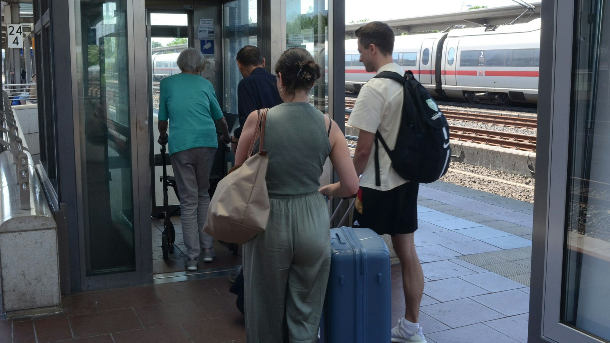 Passanten betreten einen Fahrstuhl.