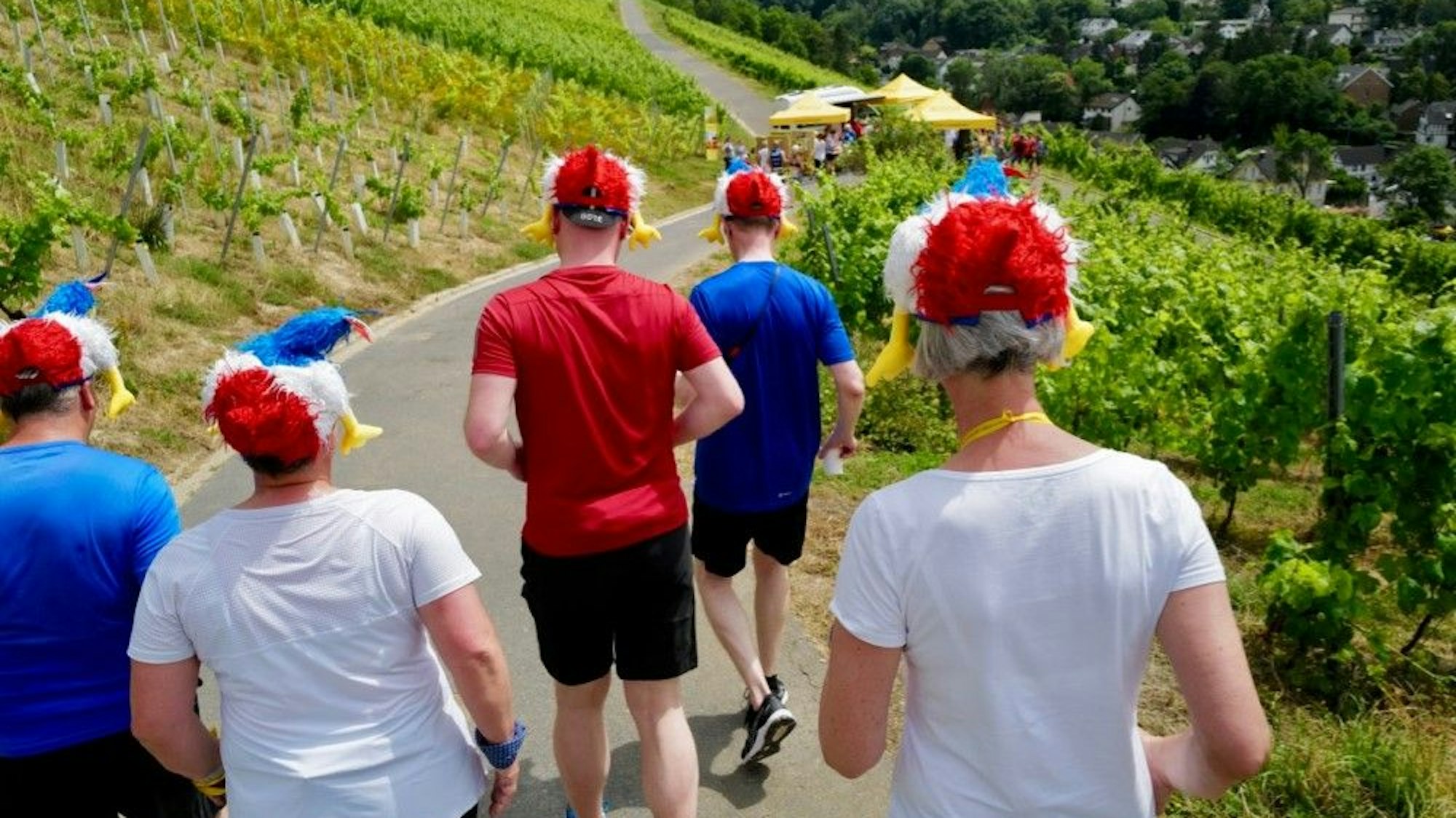 Läufer in den französischen Landesfarben tragen einen Hut in der Form des gallischen Hahns.