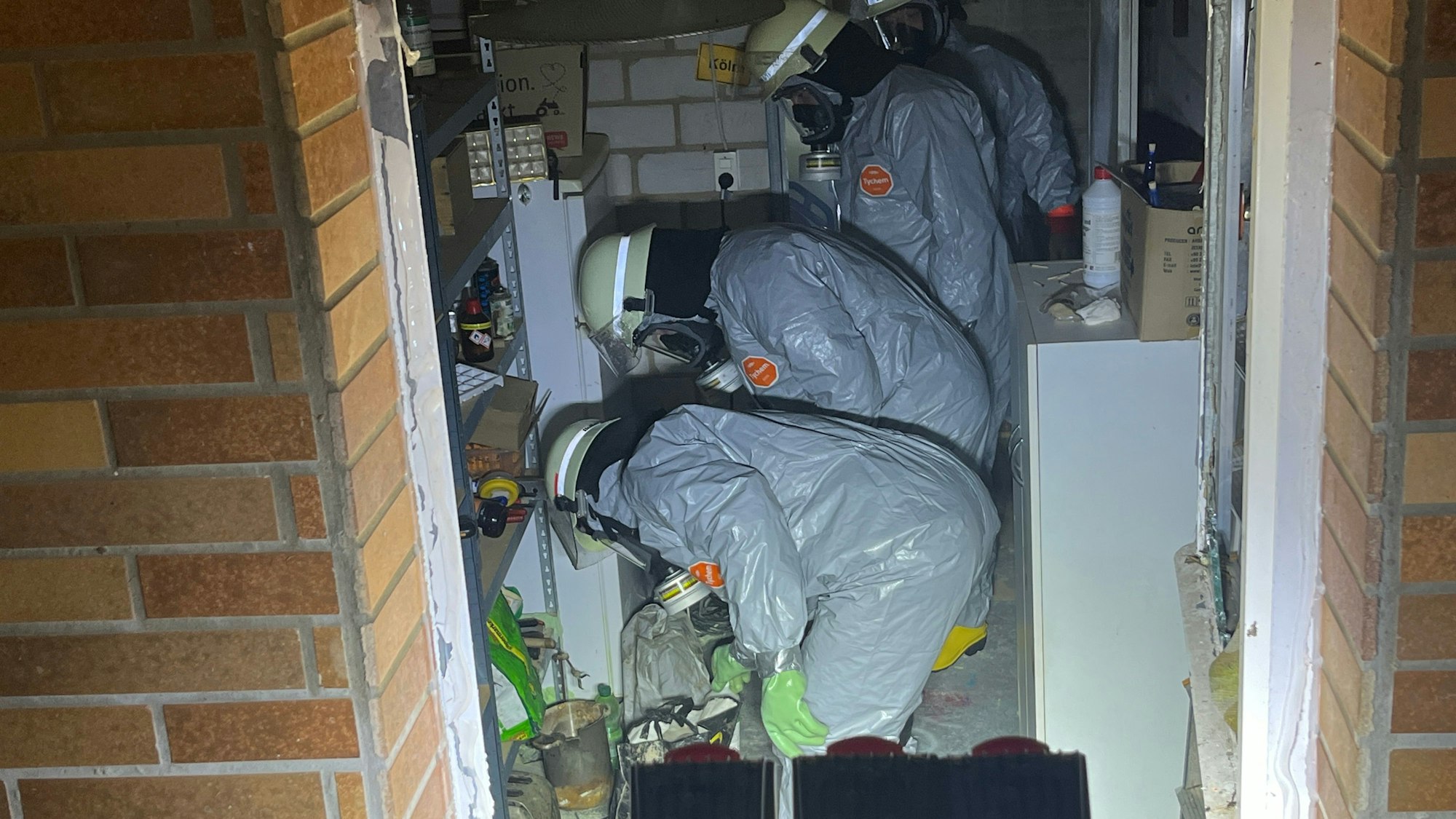 Feuerwehrleute räumen in Einmalanzüge gekleidet den Kellerraum aus und entdeckten irgendwann Sprengstoff.