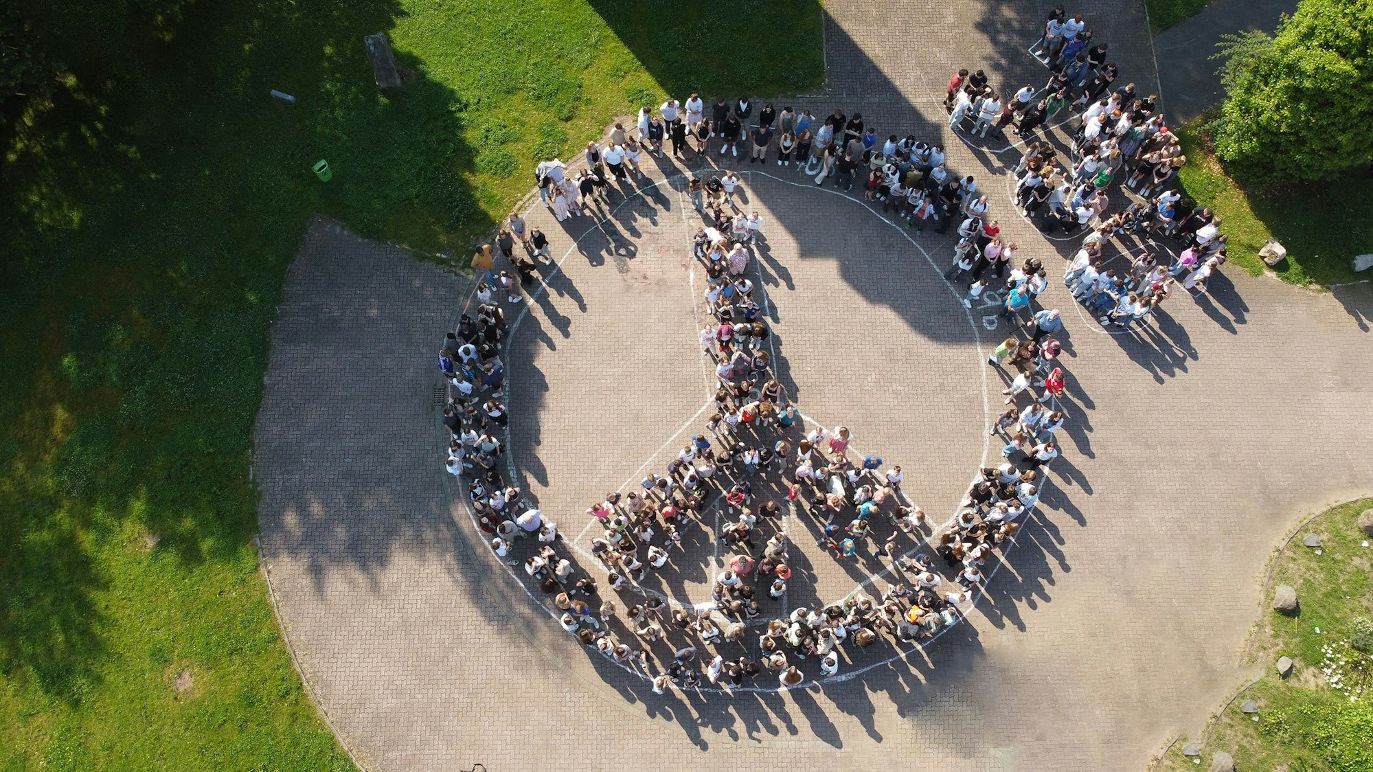 Die Luftaufnahme zeigt Schüler des Johannes-Sturmius-Gymnasiums, die sich zu einem Peace-Zeichen formiert haben.