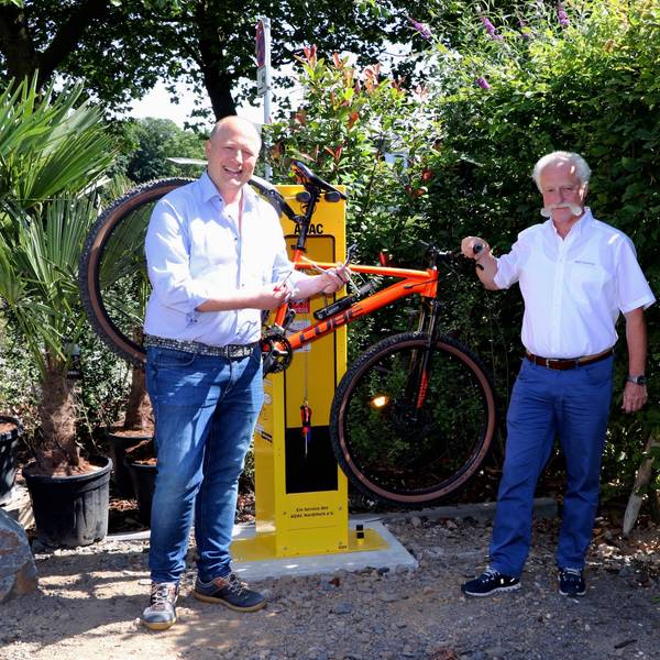 Auf dem Bild ist die neue Radstation mit zwei Männern zu sehen.