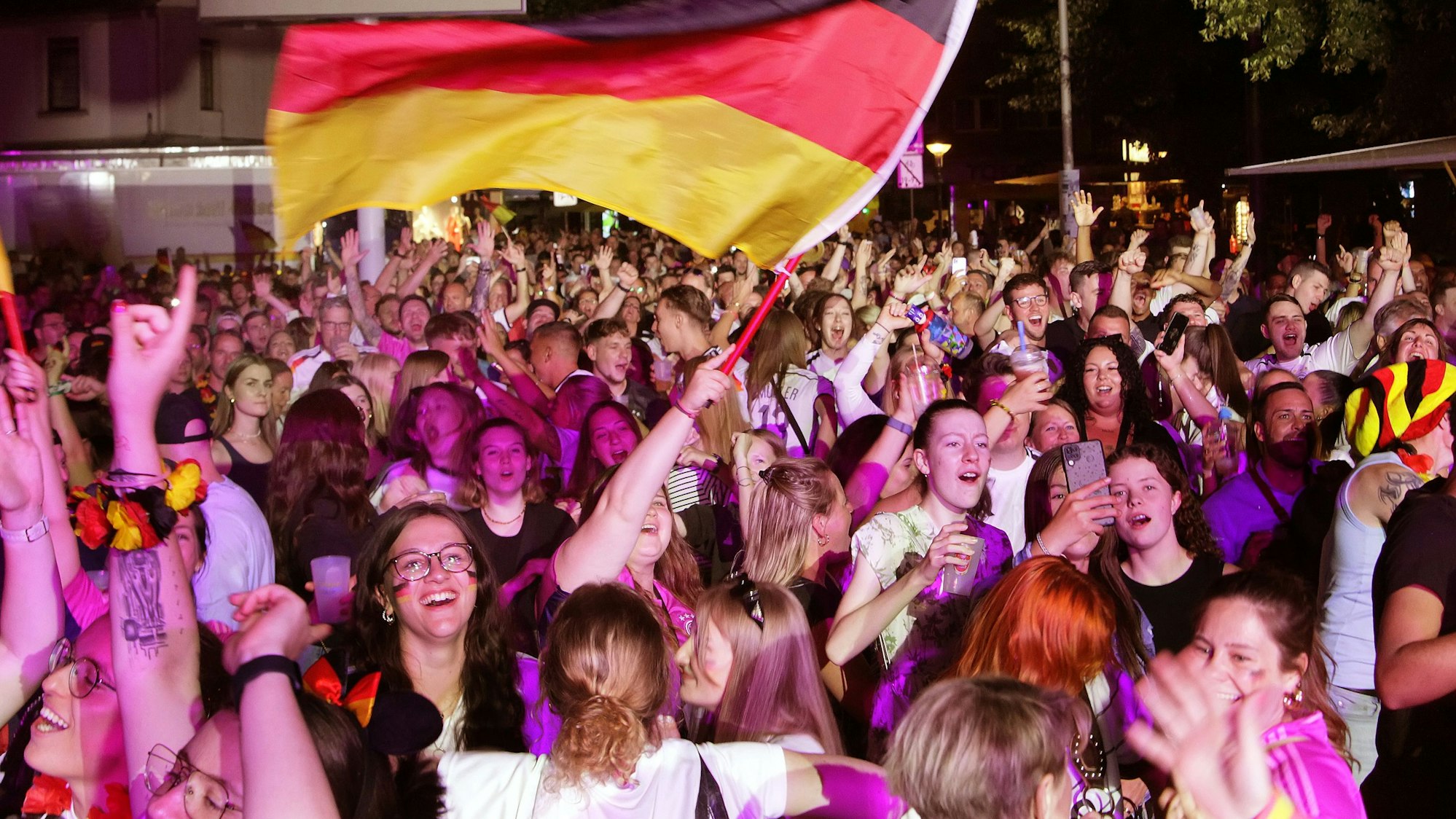 Auf dem Bild sind jubelnde Fans beim Public Viewing in Bergheim zu sehen.