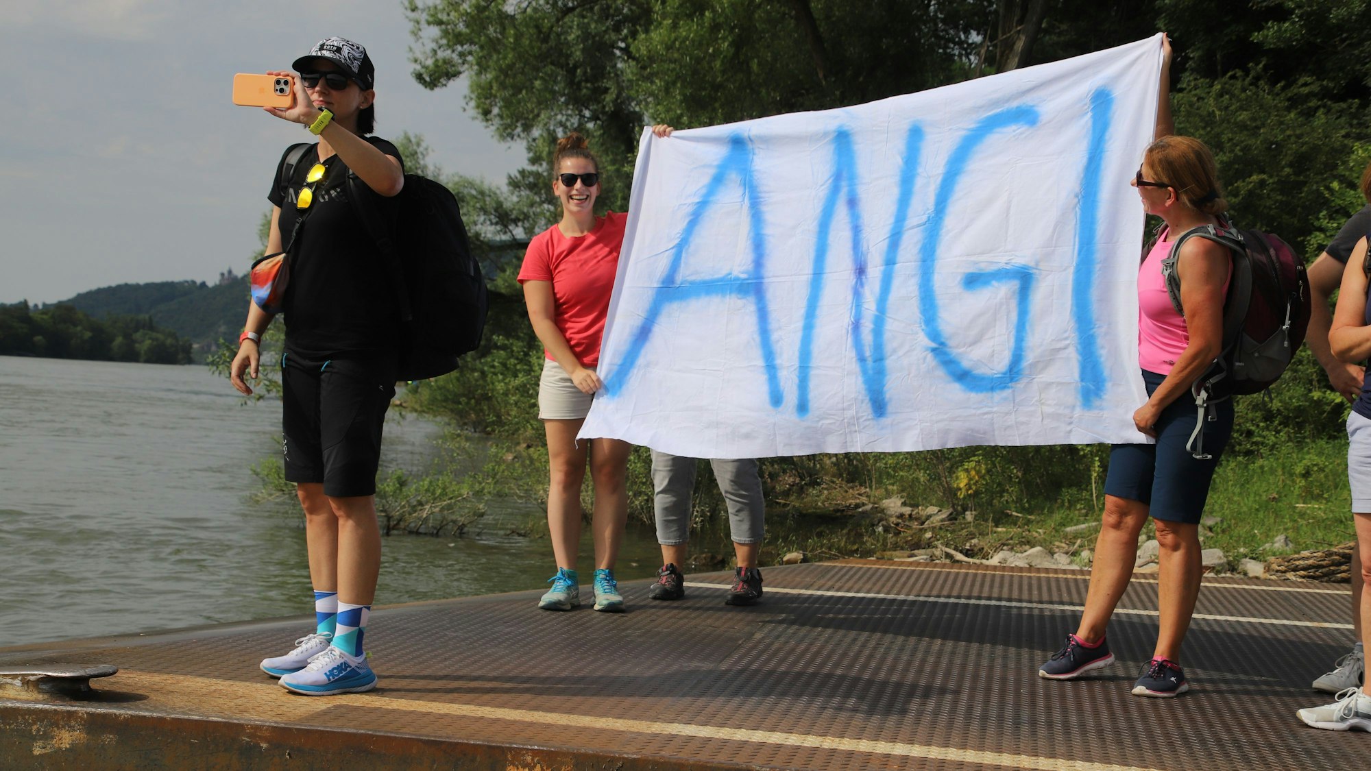 Am Ziel, der Nato-Rampe in Bad Honnef, hielten zwei Frauen ein von Hand gemaltes Tuch hoch mit der Aufschrift „Angi“ hoch: Damit hießen sie Teilnehmerin Angela Sievernich willkommen.