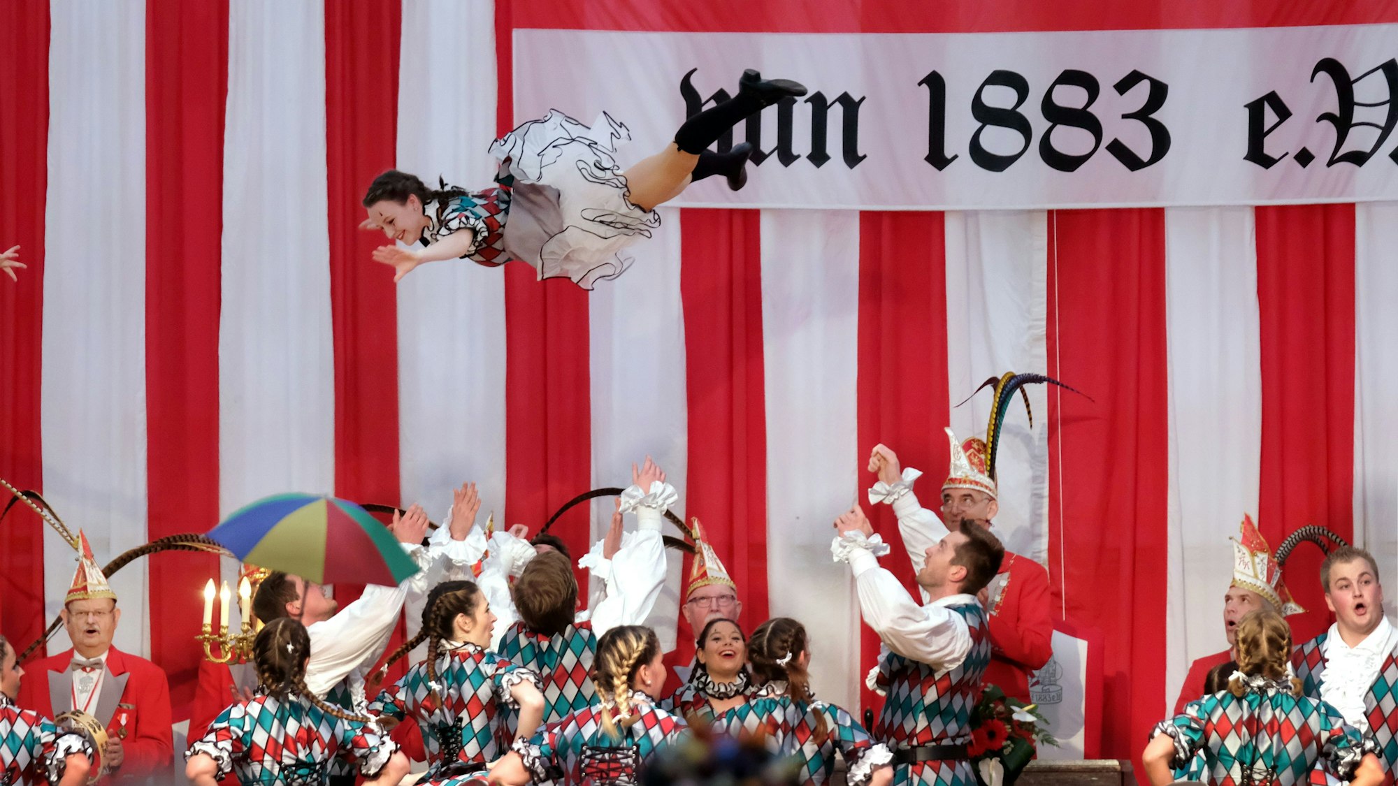 Tänzerin wird in einem Festzelt in die Höhe geworfen.
