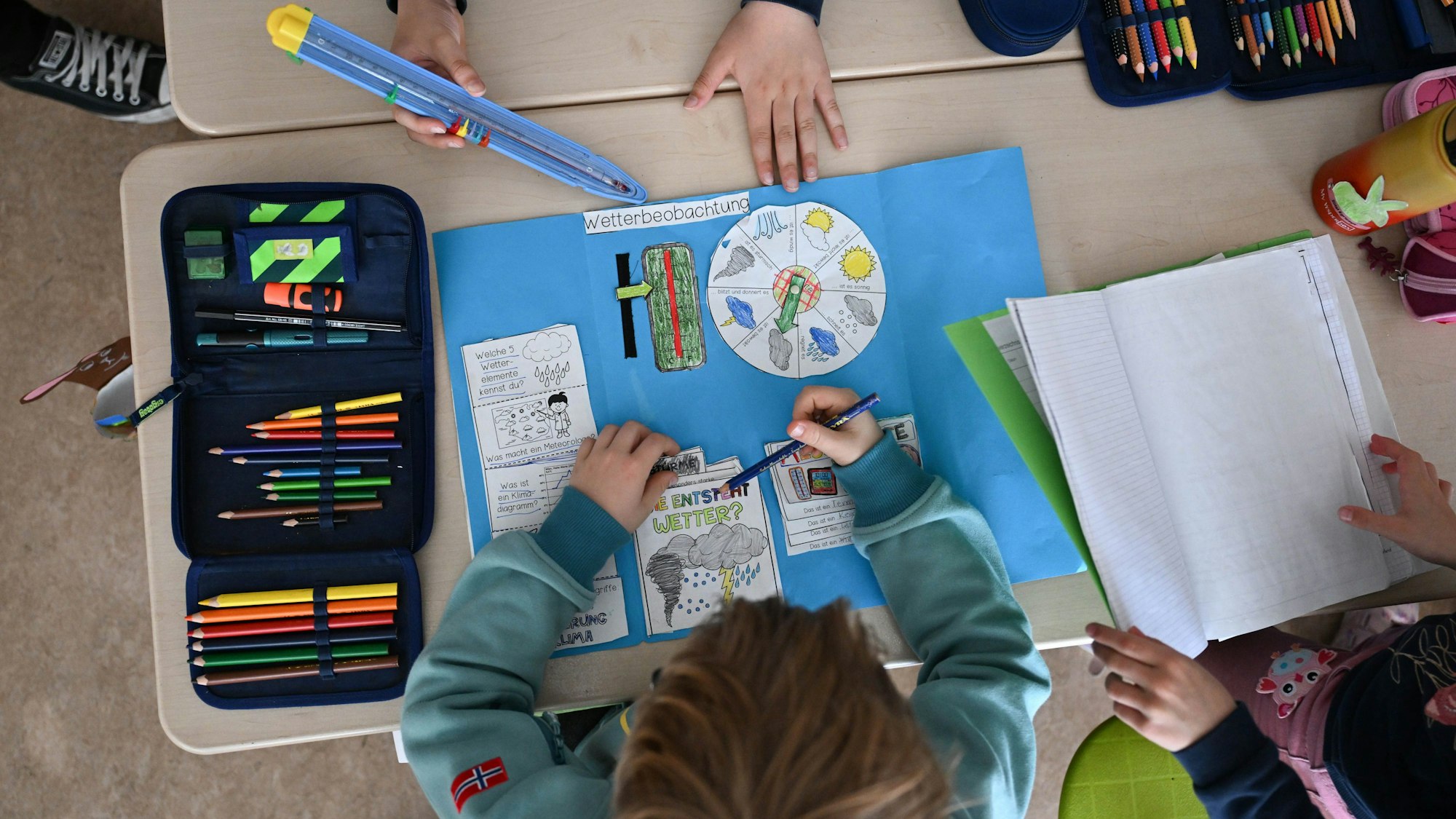 Schüler einer Grundschule arbeiten in einem Klassenzimmer in ihren Heften.