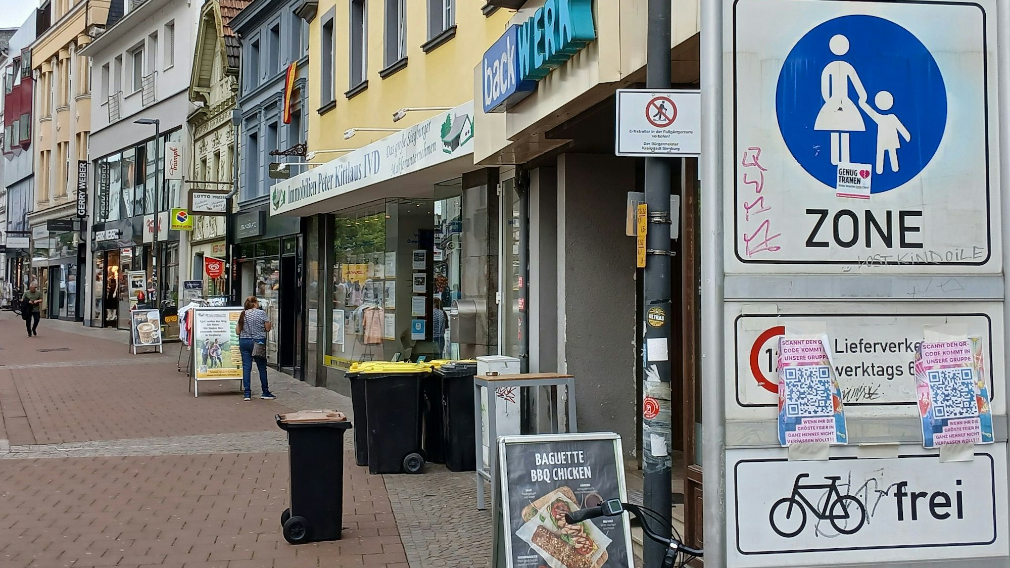 Eine Fußgängerzone, im Vordergrund ein Verkehrsschild, das ein Verbotsschild für E-Scooter verdeckt