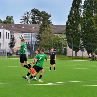 Ein Spieler macht einen Kopfball beim Eröffnungsspiel auf dem neuen Kunstrasenplatz.