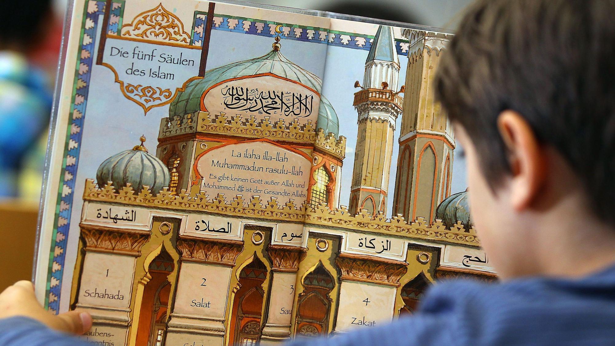 Ein Junge liest während des islamischen Religionsunterrichts in Bonn in einem Schulbuch.
