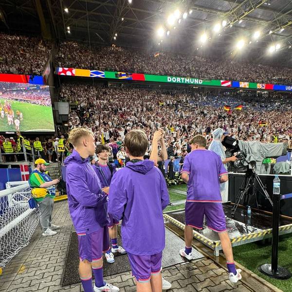 Julian Seliger aus Kirspenich war beim EM-Spiel Deutschland gegen Dänemark als Balljunge dabei. Auf dem Bild ist er links mit drei anderen Balljungen in lila Shirts vor den vollen Rängen des Stadions in Dortmund zu sehen.