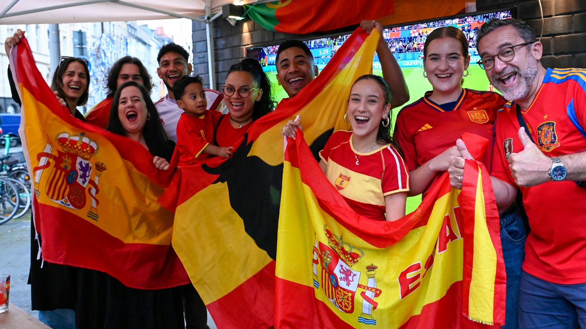 Das Bild zeigt eine Gruppe von Menschen mit spanischen Flaggen.