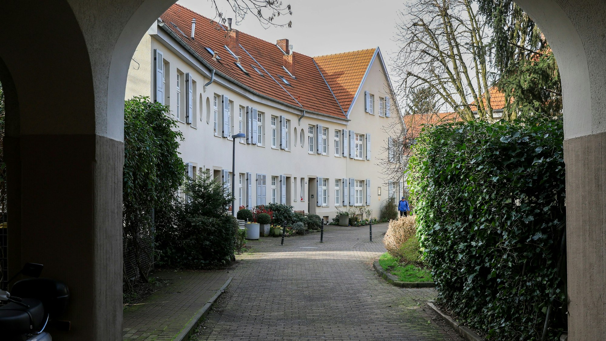 Zu sehen ist eine Häuserzeile durch einen Torbogen hindurch.