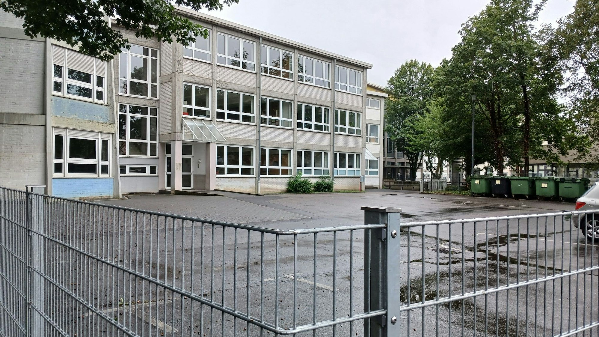 Ein Schulgebäude hinter einem Gitterzaun