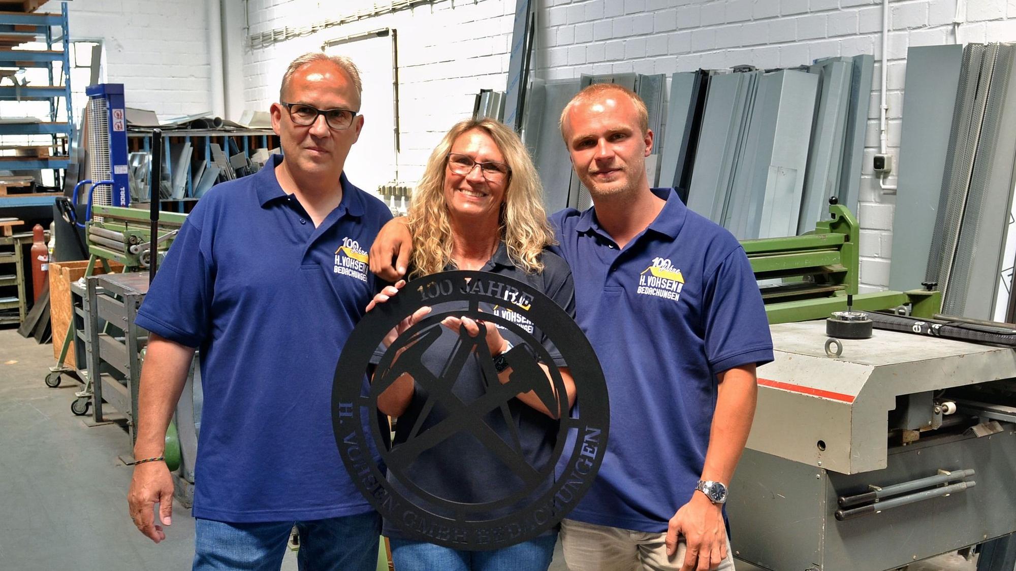 Dirk, Ruth und Marcel Schindler posieren in der Werkstatt für ein Foto.