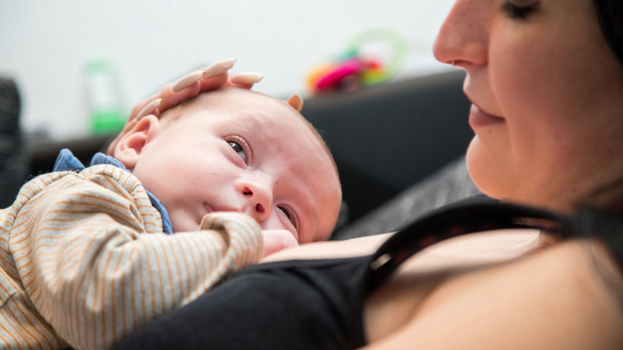 Ein Säugling liegt auf der Brust seiner Mutter.