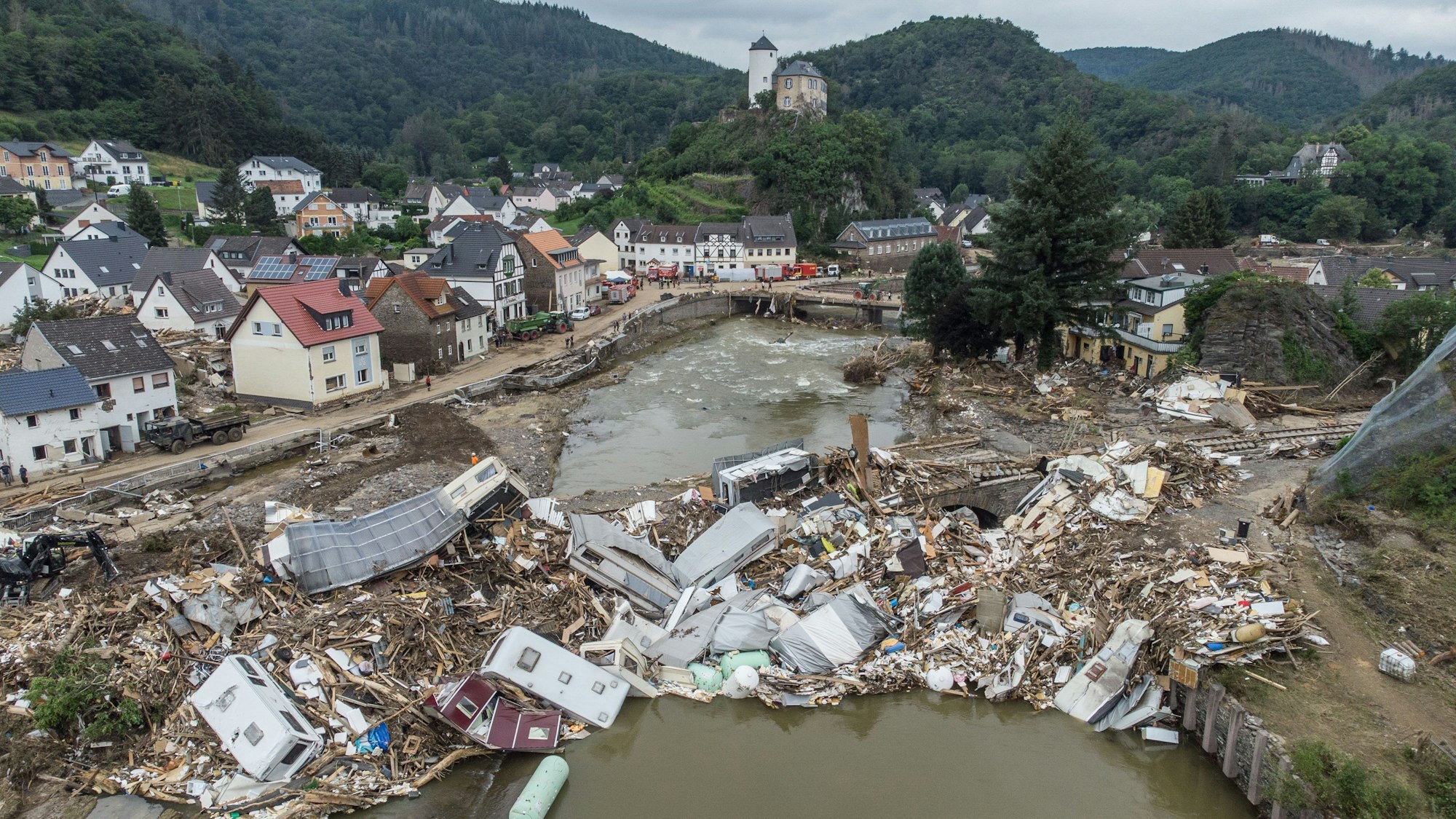 ARCHIV - 19.07.2021, Rheinland-Pfalz, Altenahr: Meterhoch türmen sich Wohnwagen, Gastanks, Bäume und Schrott an einer Brücke über der Ahr in Altenahr (Luftaufnahme mit einer Drohne).