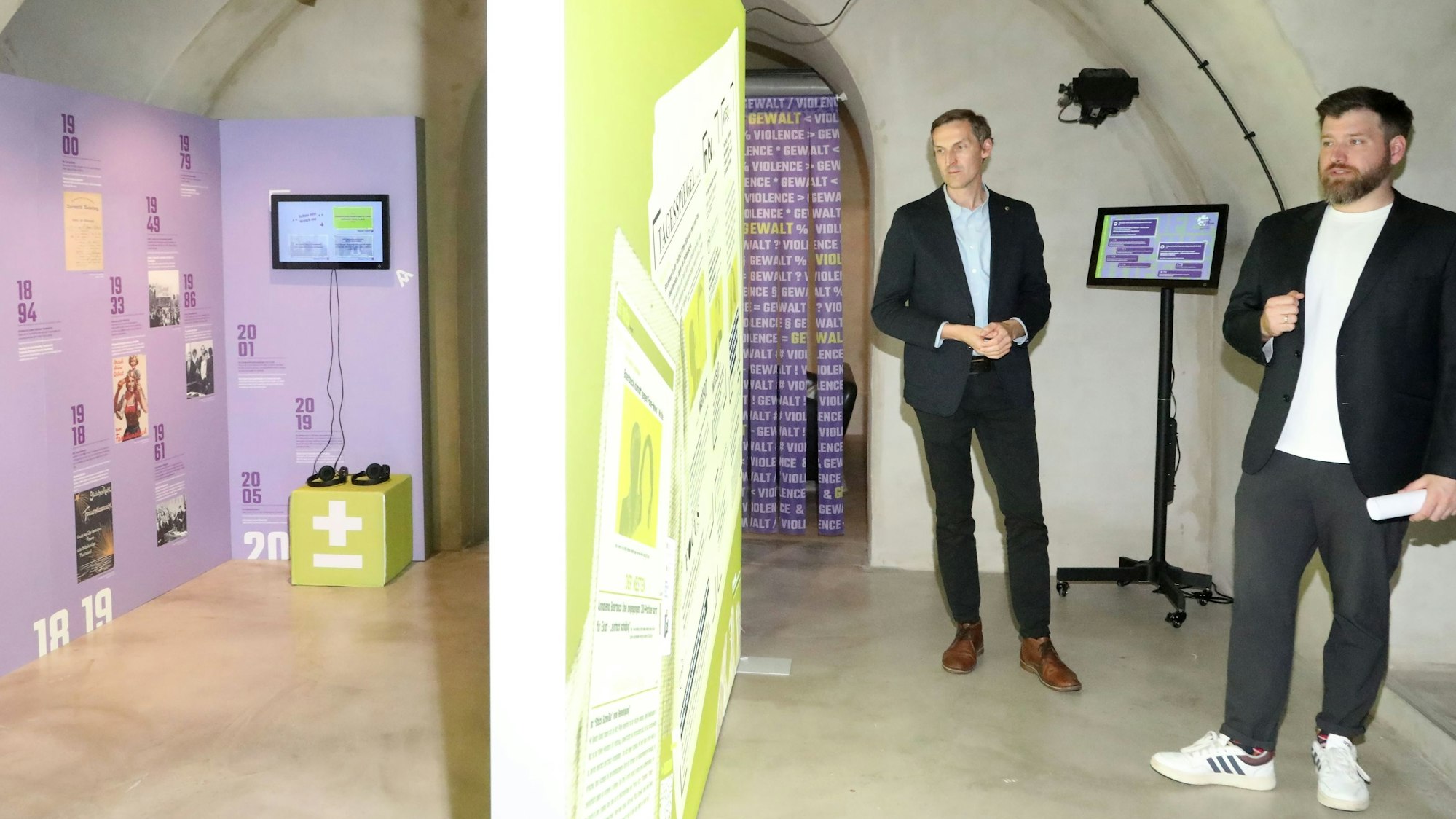 Zu sehen sind zwei Männer, die vor einer Infotafel im NS-DOK Zentrum in Köln stehen, Henning Borggräfe und Ilja Gold