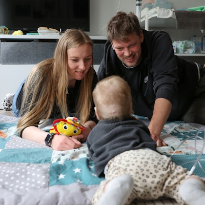 Sandra und Jens Leuschen spielen mit ihrer jüngsten Tochter Lucy auf einer Babydecke.