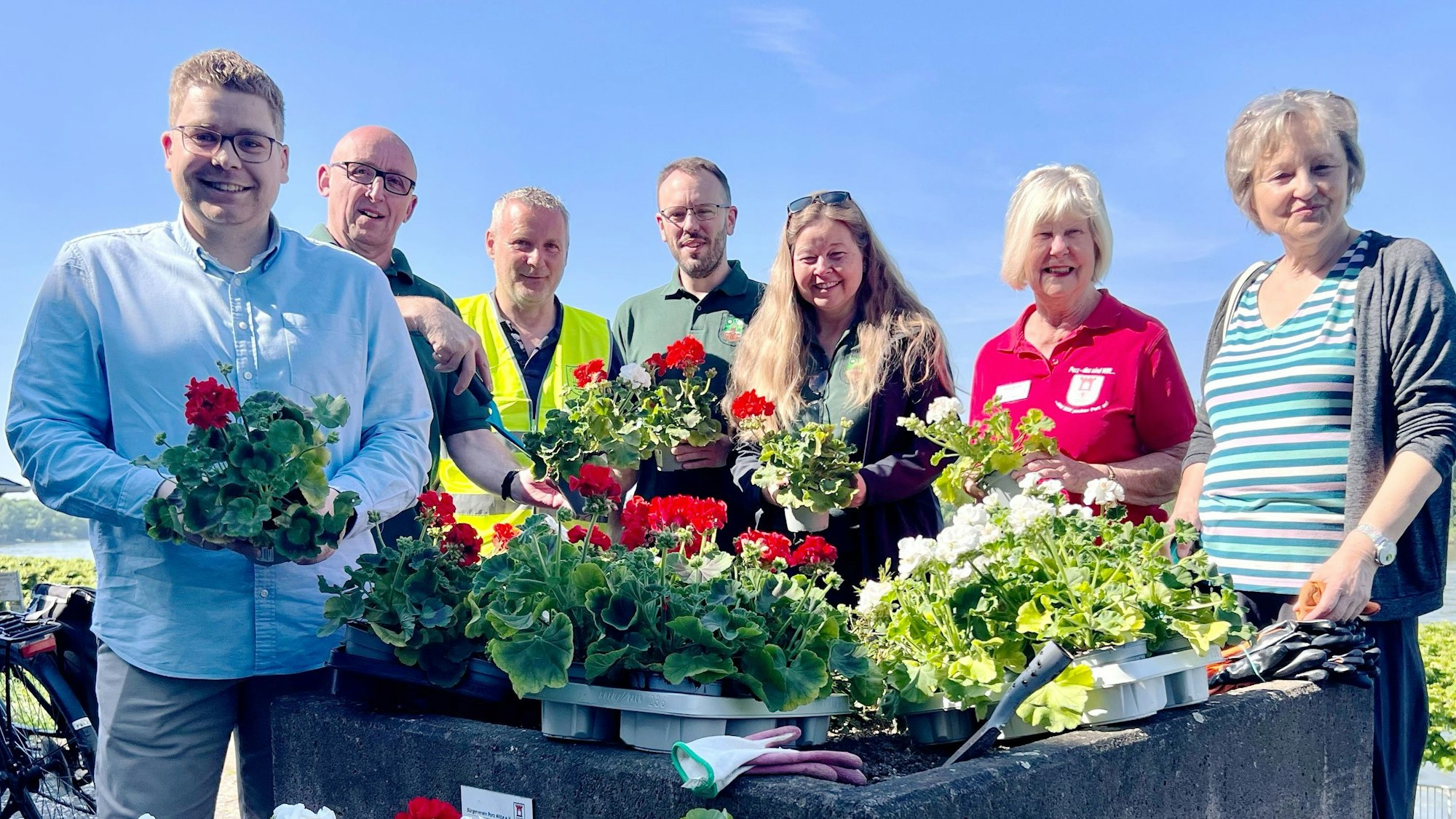 Die Blumenkübel am Rheinufer haben Vertreterinnen und Vertreter von Porzer Schützenvereinen zusammen mit dem Bürgerverein Porz-Mitte bepflanzt.