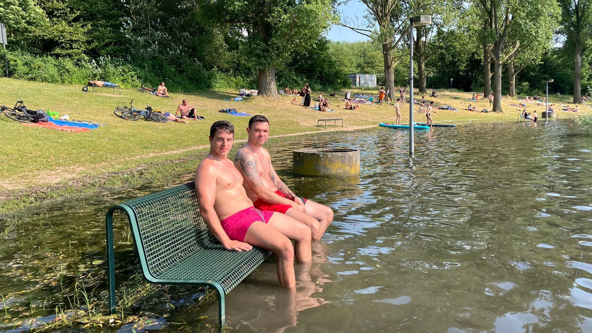 Parkbank im Wasser? Florian Wagner (links) gefällt sie so besser: Er kühlt mit einem Freund die Füße im See ab.