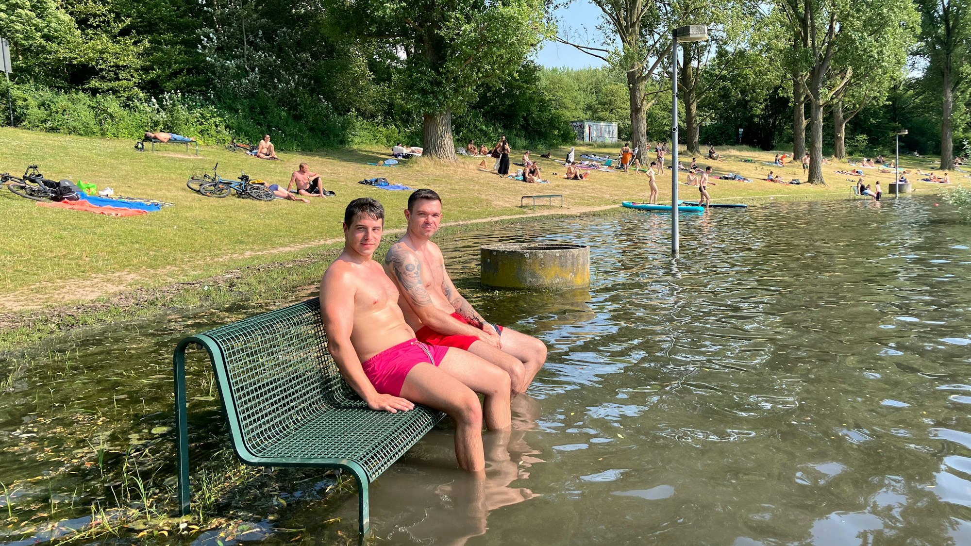 Parkbank im Wasser? Florian Wagner (links) gefällt sie so besser: Er kühlt mit einem Freund die Füße im See ab.