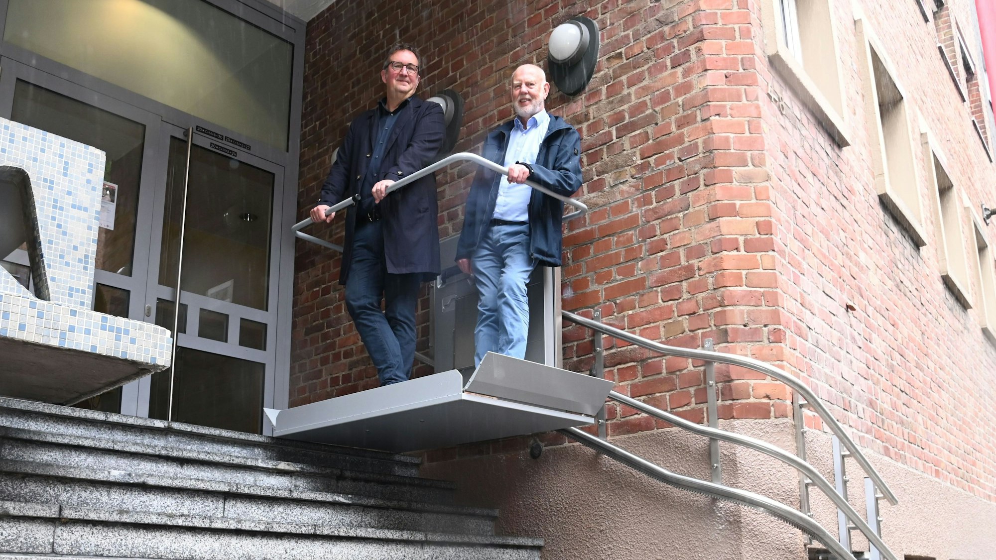 Akademieleiter Norbert Bauer (links) und Werner Höbsch, Vorsitzender des Trägervereins, testen den neuen Lift zur Karl-Rahner-Akademie in der Innenstadt.
