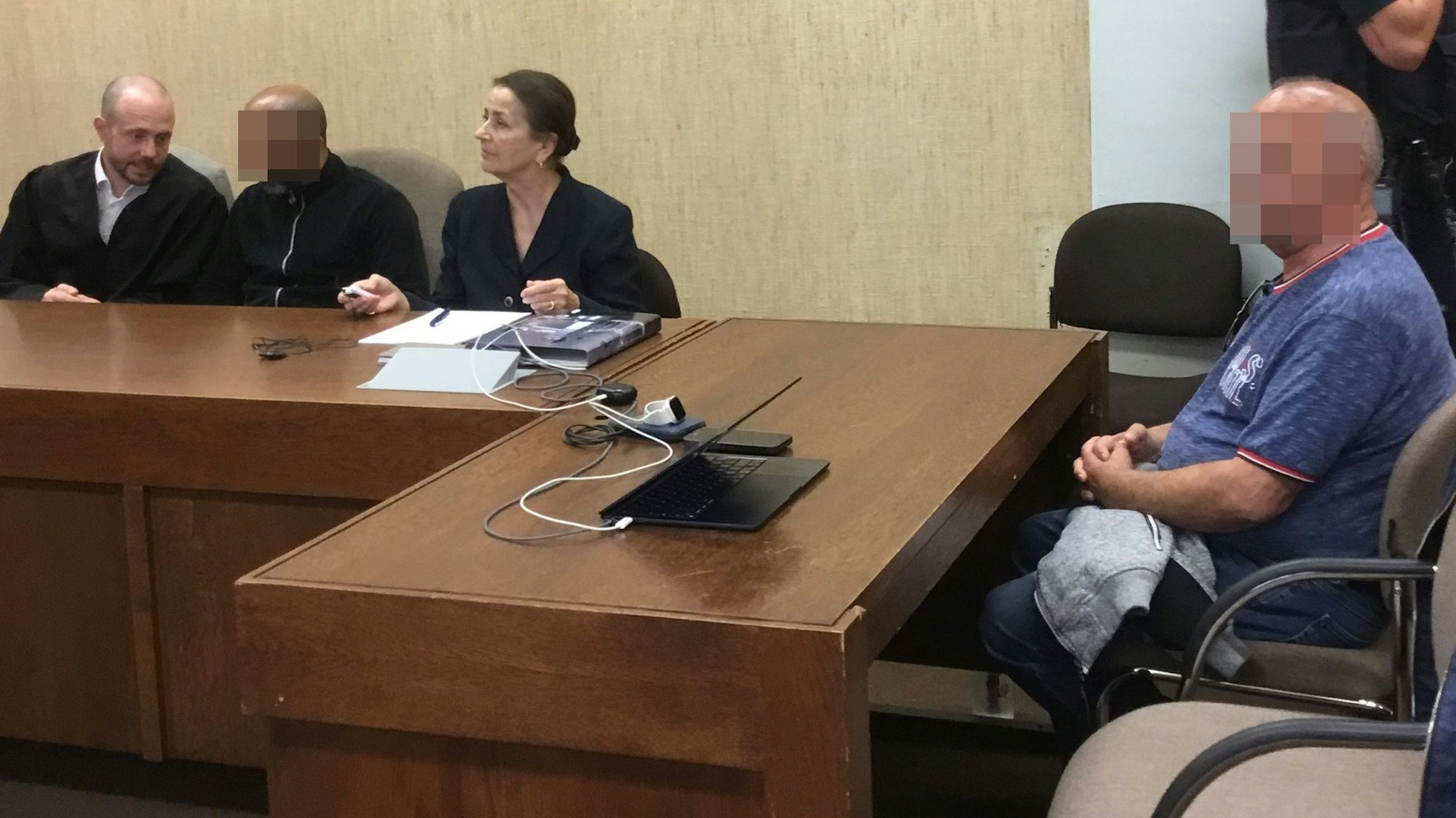 Die Angeklagten mit Verteidiger Markus Haupt und einer Dolmetscherin beim Prozessaauftakt im Landgericht Köln