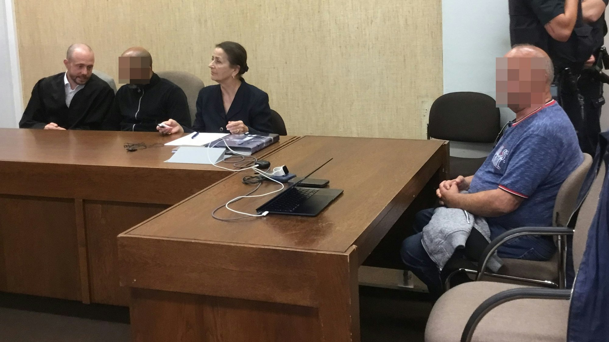 Die Angeklagten mit Verteidiger Markus Haupt und einer Dolmetscherin beim Prozessaauftakt im Landgericht Köln