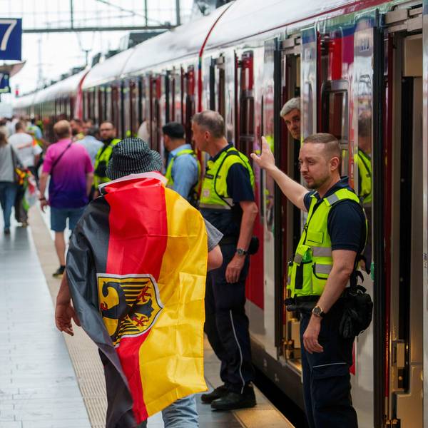 23.06.2024, Hessen, Frankfurt/Main: Fußball, UEFA Euro 2024, EM, Schweiz - Deutschland, Vorrunde, Gruppe A, Spieltag 3, Frankfurt Arena, Sicherheitspersonal der Bahn weisst einem deutschen Fan den Weg zu einem freien Abteil, ganz am Ende des Zuges. Fussballfans die mit dem Zug ab Hauptbahnhof zum Deutsche Bank Park, dem Austragungsort der Begegnung Schweiz - Deutschland, kommen wollen, werden hart geprüft. Die Menschen müssen in völlig überfüllten und verspäteten Zügen bei hohen Temperaturen ausharren. Foto: Andreas Arnold/dpa +++ dpa-Bildfunk +++