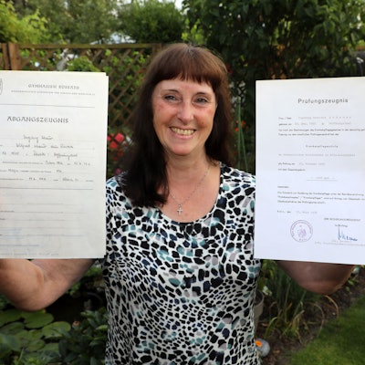 DRK-Kreisvorsitzende Ingeborg Schmidt aus Rösrath hält zwei Zeugnisse in den Händen.