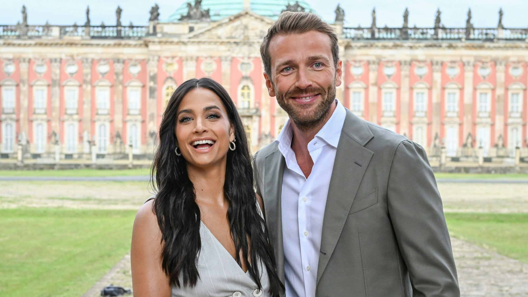 Amira Pocher und Christian Düren kommen zur Show des Labels Marc Cain in die Kolonnaden mit Triumphtor am Neuen Palais.