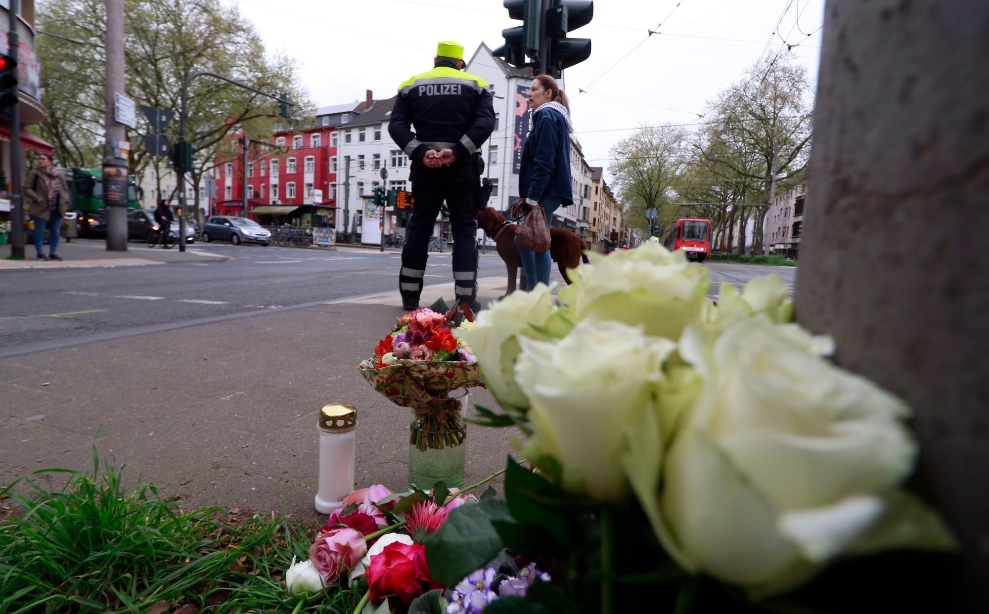 Blumen und Polizei am Unfallort an der Ecke Sülzgürtel/Luxemburger Straße für die 63-jährige Radfahrerin, die im April 2023 hier verstarb.