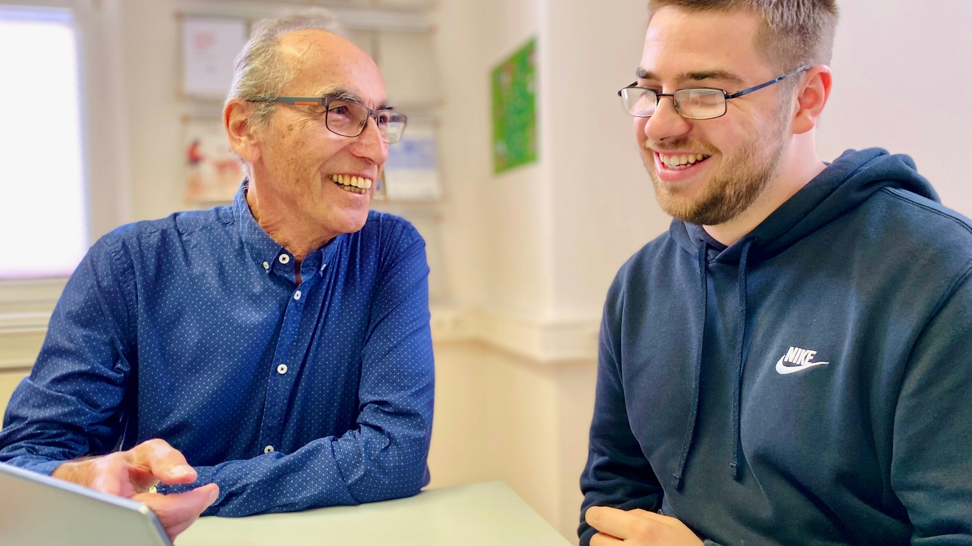 Gerhard Schratt und André Wilms sitzen an einem Laptop.