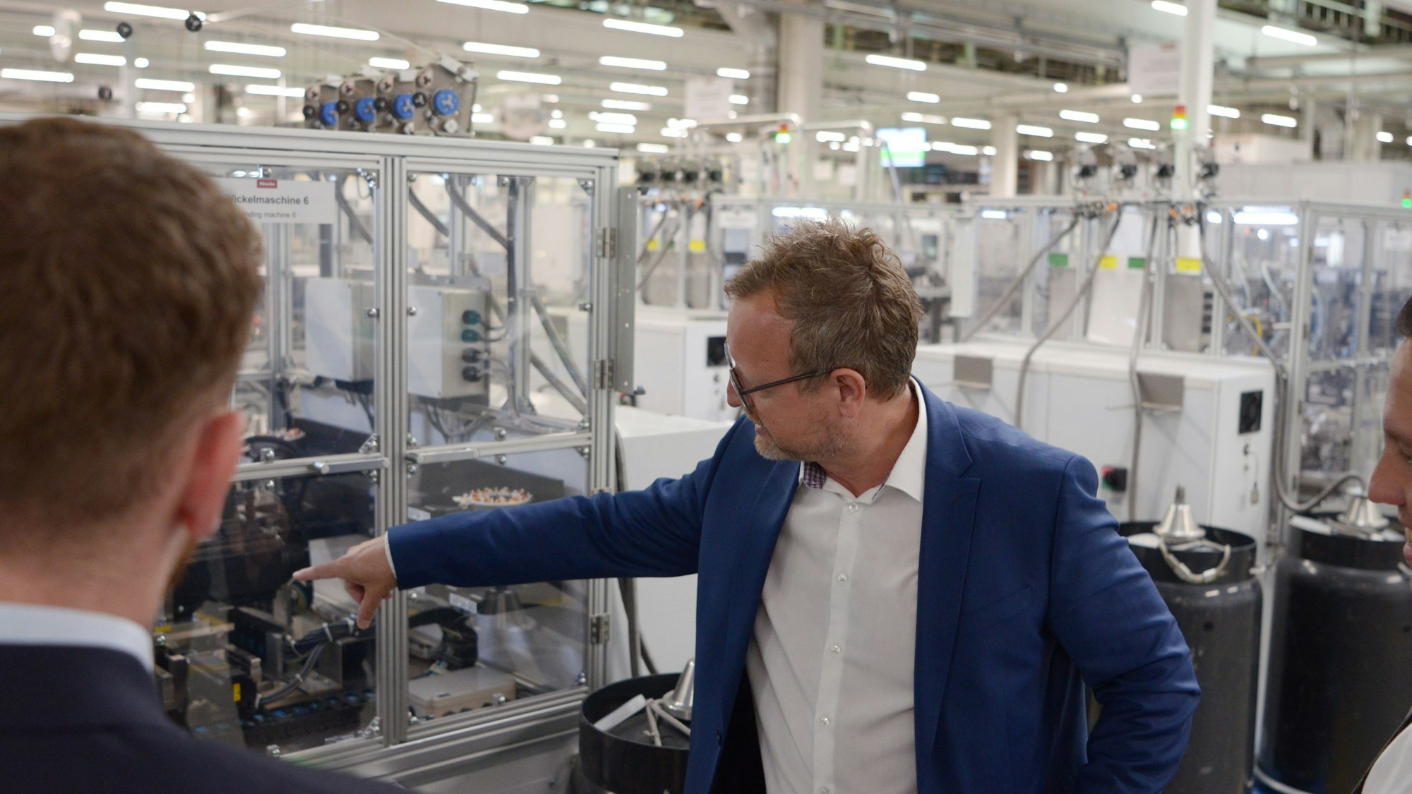 Jürgen Zdunek deutet auf eine Produktionsanlage.