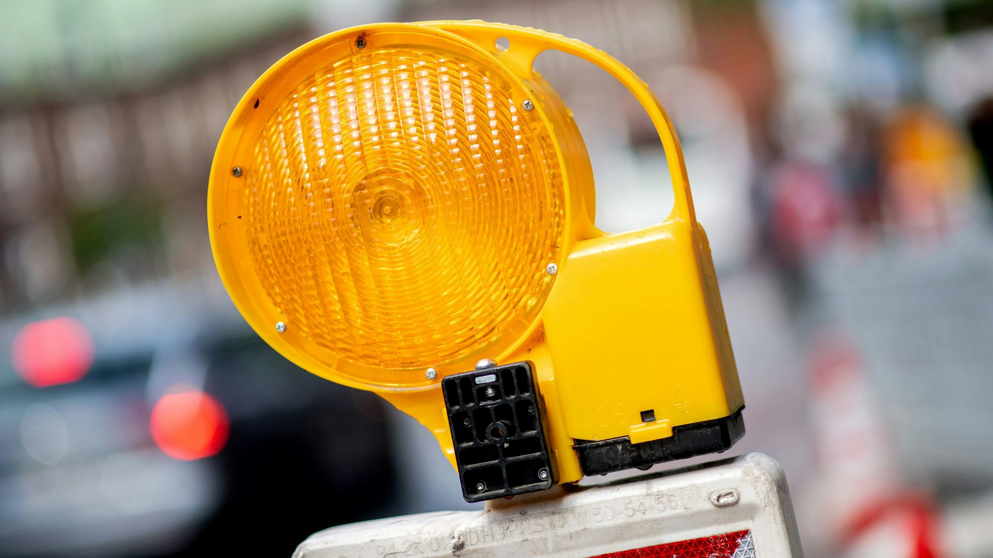 Eine Leitbake mit einer Warnleuchte steht auf einer Straße