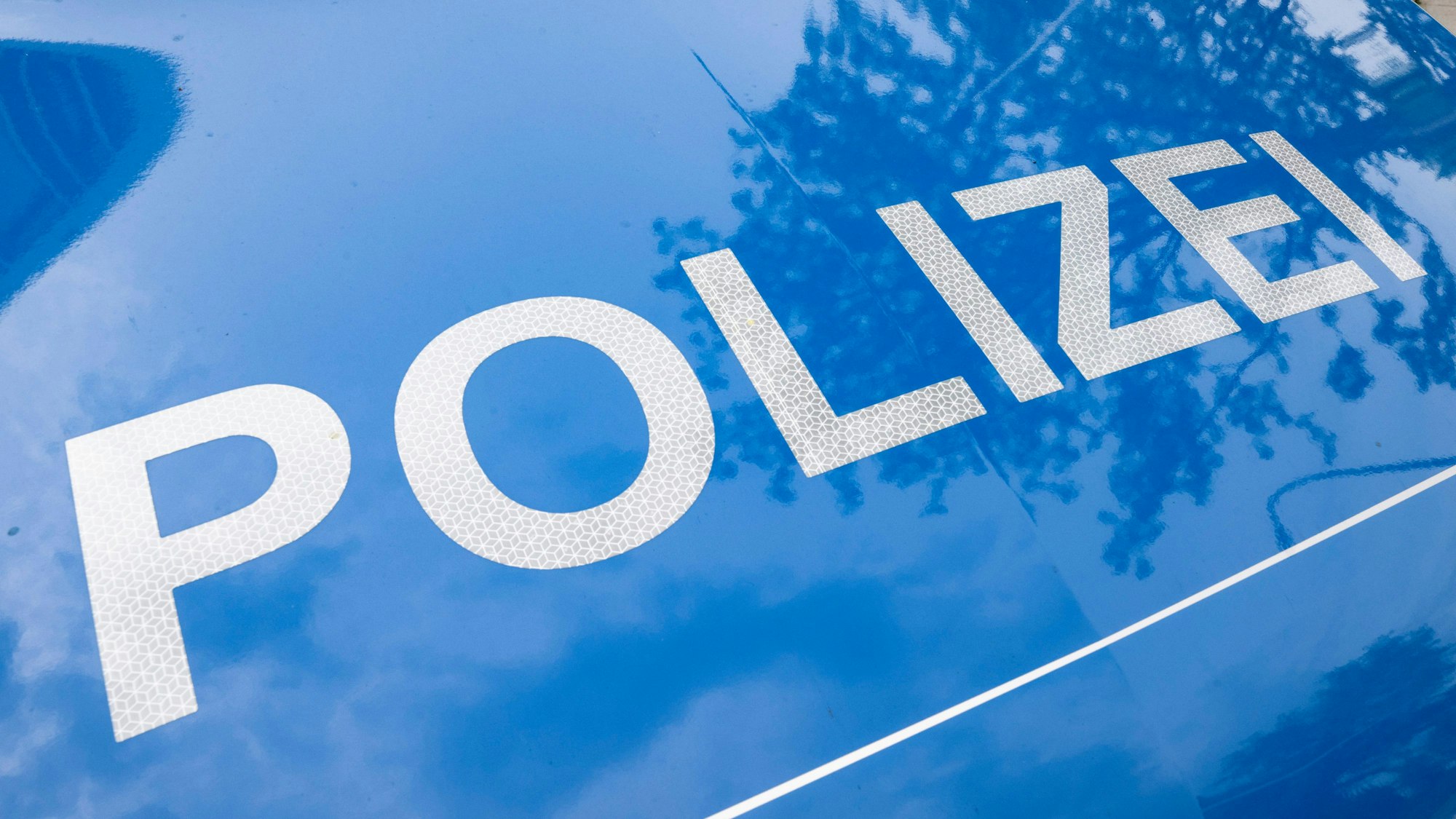 Das Bild zeigt den Schriftzug Polizei auf einem Streifenwagen.