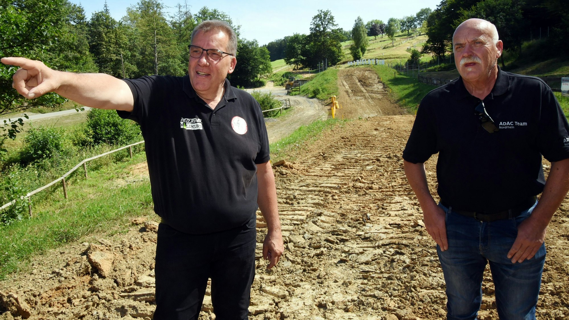 Zu sehen sind zwei Männer auf einer Motocross-Strecke