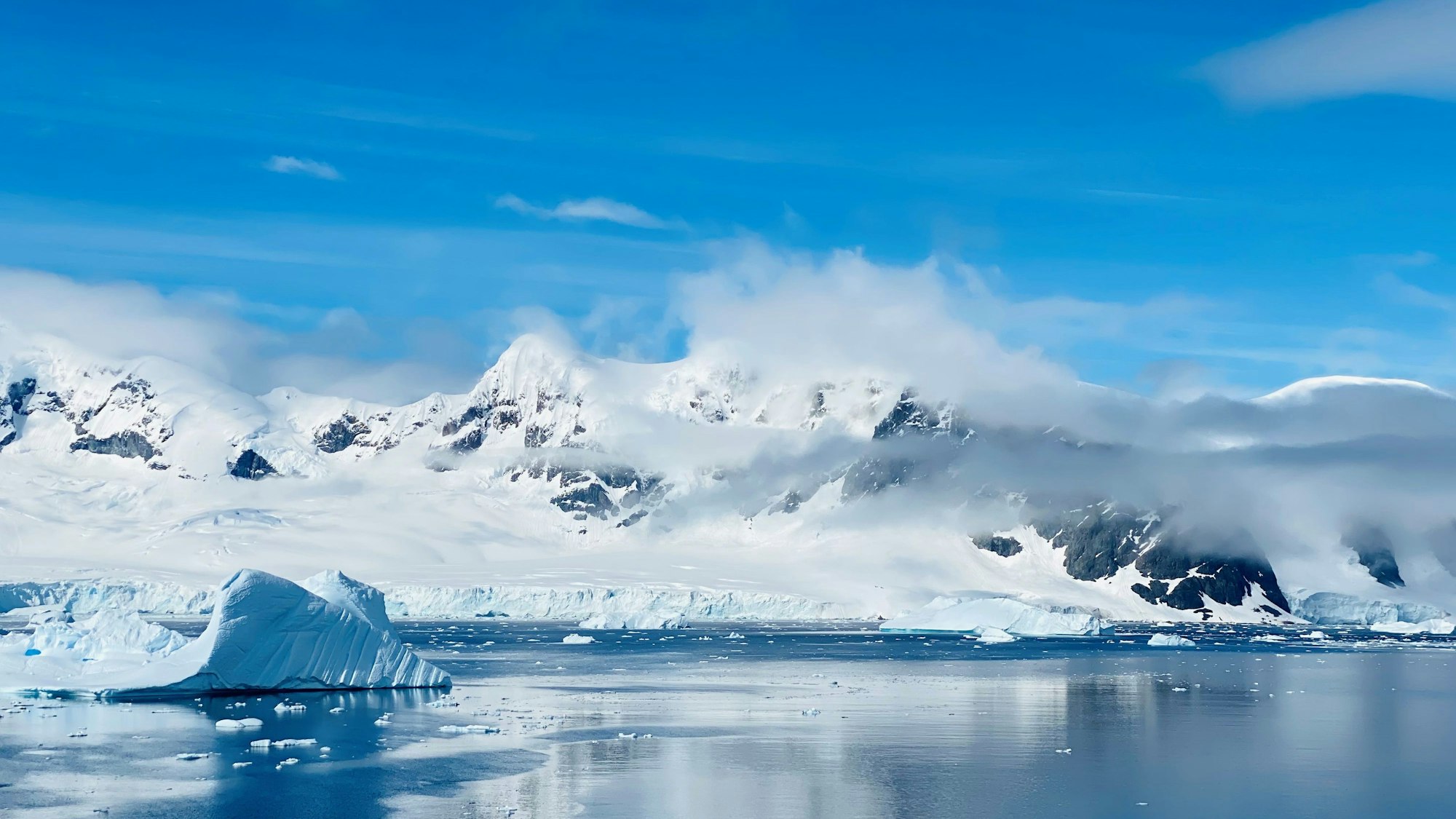 Wasser, Eisberge, Felsen und blauer Himmel.