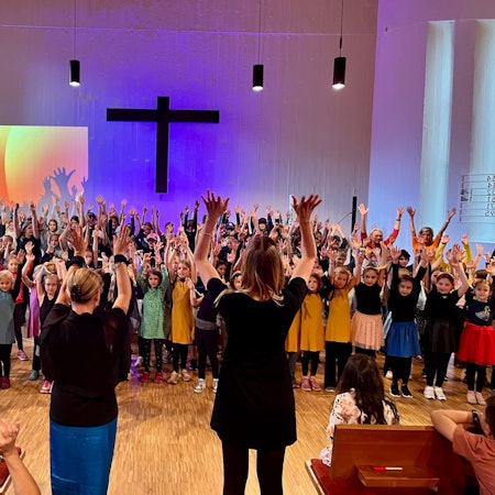 Viele Kinder auf einer Kirchenbühne