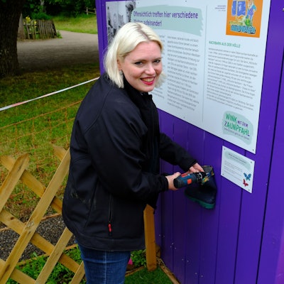 Margarethe Becker, Ausstellungskuratorin des Museums, schraubt mit einem Akkuschrauber eine Schraube fest.