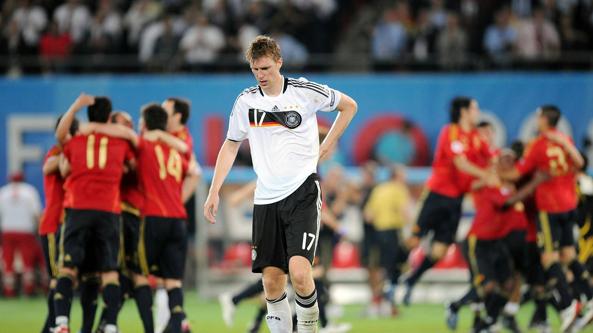 Per Mertesacker steht enttäuscht vor jubelnden Spaniern nach dem EM-Finale 2008.